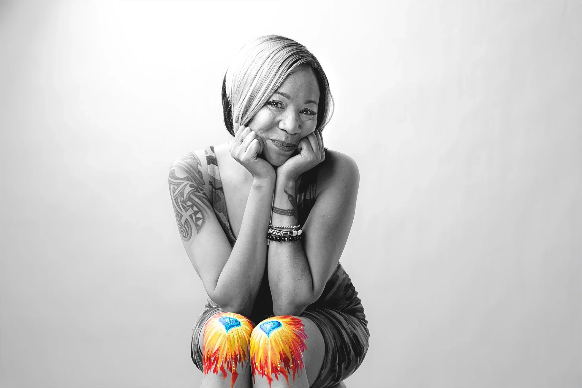 A black and white portrait of a woman with painted knees