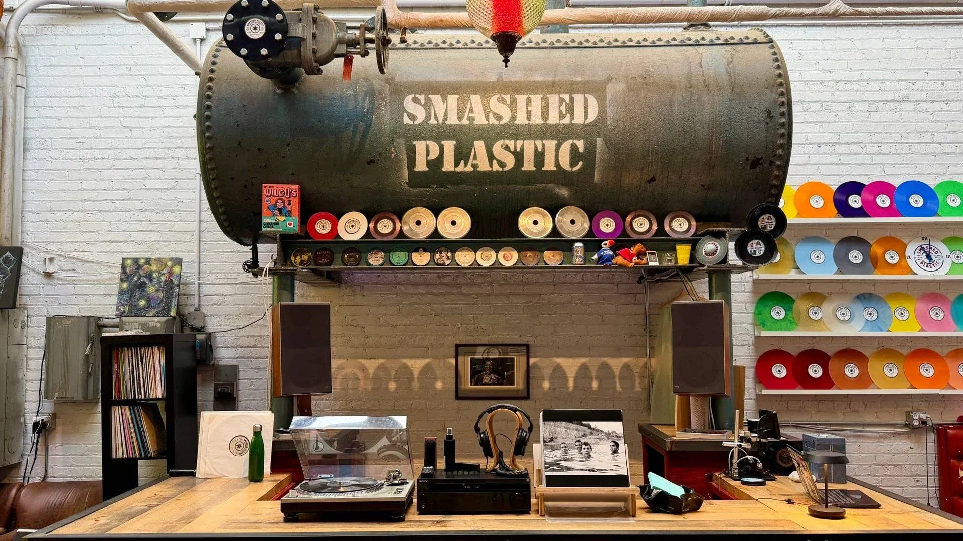 A room with a Smashed Plastic sign above shelves of records